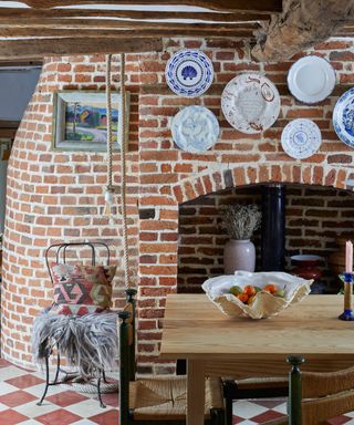 rustic dining room with exposed brick wall and hanging wall plates